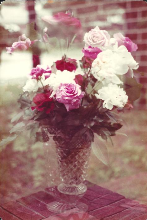 a vase of muli colored roses