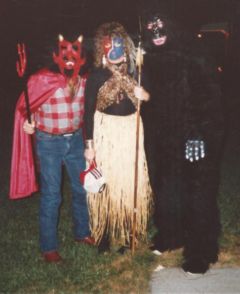 People in halloween costumes; devil, gorilla, native in grass skirt